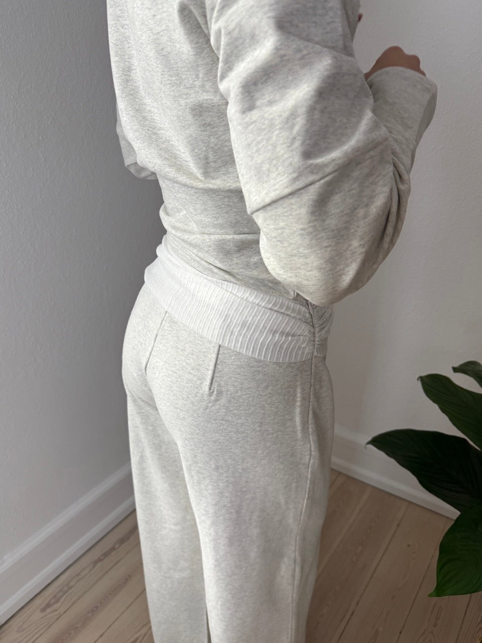 Model iført KLARA grå bukser med chiffonbælte