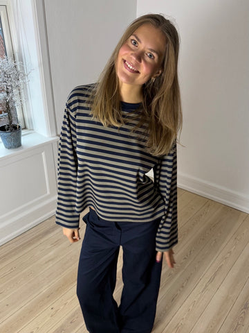 Model iført SELMA stribet bluse i navyblå og grøn